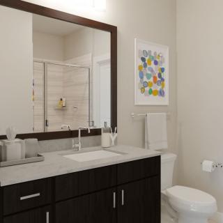 A modern bathroom with a large mirror, sink, and toilet, featuring colorful artwork on the wall.