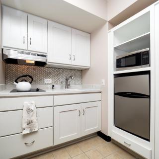 A modern kitchen with white cabinets and stainless steel appliances.