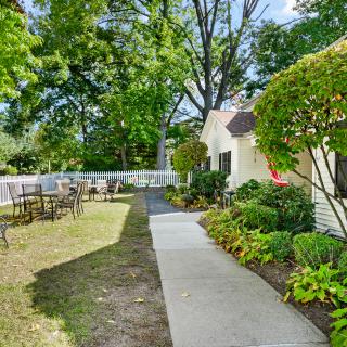 A serene outdoor walkway lined with greenery and seating areas.