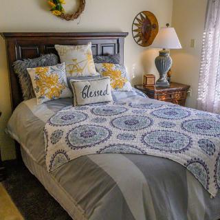 A cozy bedroom with patterned bedding and decorative pillows.