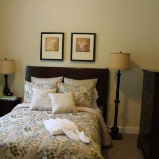 Cozy bedroom with decorative pillows and matching lamps.