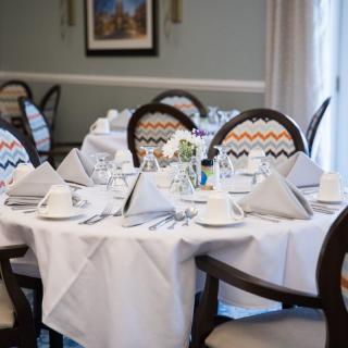 An elegantly set dining table in a restaurant, featuring neatly arranged napkins and glassware.