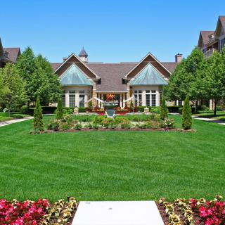A beautiful house surrounded by a well-manicured lawn and landscaped garden.
