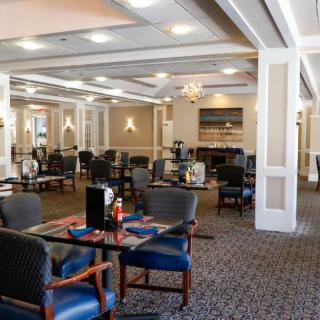 An elegantly designed dining area with well-arranged tables and chairs, featuring warm lighting and decor.