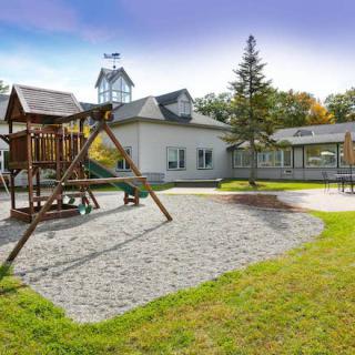 A serene playground with swingset and surrounding buildings under a clear sky.
