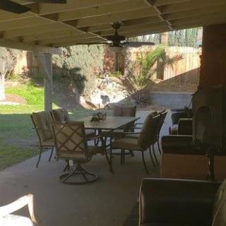 A cozy outdoor patio setup with a table, chairs, and a covered area in the backyard.