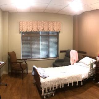 A calm and simple hospital room equipped with a patient bed and basic furnishings.