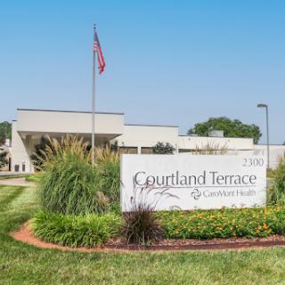 Entrance of Courtland Terrace with a prominent sign and landscaped surroundings.