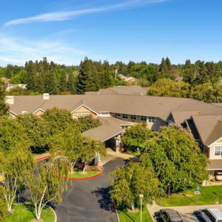 Aerial view of a large residential building surrounded by lush trees.