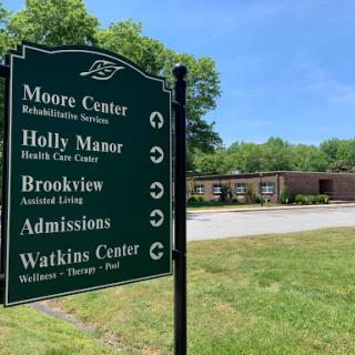 Signage indicating directions to various facilities, including Moore Center and admissions.