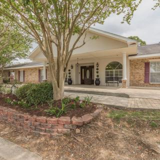 A suburban house with a neatly landscaped front yard and driveway.