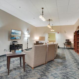 A spacious living room with a cozy sofa, television, and elegant lighting.