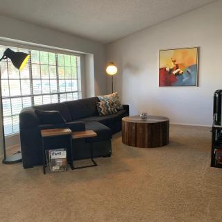 A cozy living room with a comfortable sofa, modern coffee table, and stylish floor lamp next to a large window.