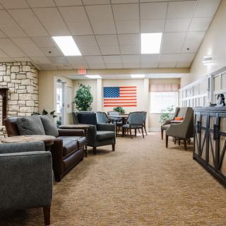 A cozy living room with sofas, chairs, and an American flag decoration.