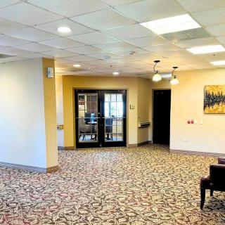 A spacious and well-lit lobby area with carpeted flooring and modern lighting.