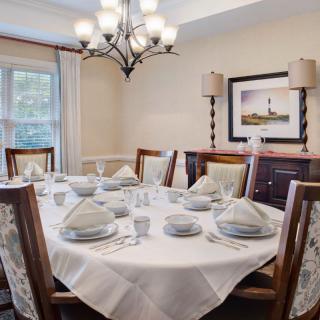A beautifully set dining table with elegant decor and a chandelier.