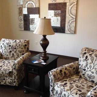 A cozy living room setup with patterned armchairs and decorative wall art.