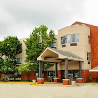 A modern hotel building featuring a welcoming entrance and landscaped surroundings.