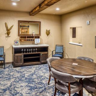 A cozy dining room with a round table, upholstered chairs, and elegant decor.