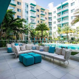 Modern apartment complex with a stylish outdoor pool area and patio seating.
