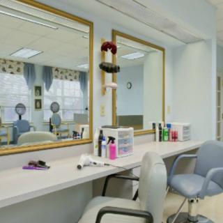A hair salon interior with mirrors, chairs, and beauty products arranged on the counter.