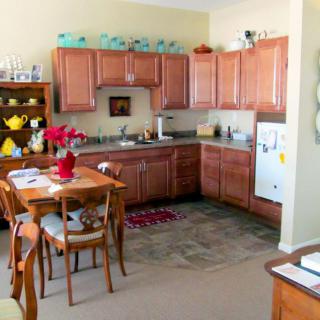 A cozy kitchen with wooden cabinets, a small dining table set, and some decorative items.
