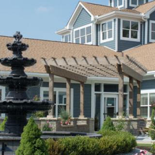 A beautiful outdoor view featuring a fountain in front of a modern blue building.