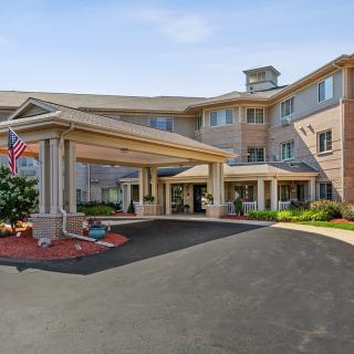 A hotel entrance with a covered driveway and well-maintained landscaping.