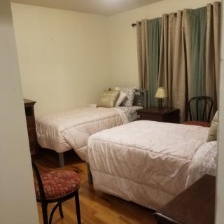 A cozy bedroom with two beds and simple furnishings.
