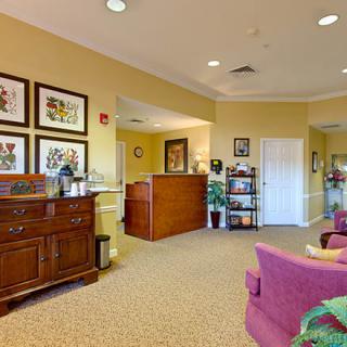 A cozy reception area featuring comfortable seating, decorative wall art, and a welcoming desk.
