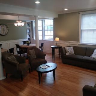 A cozy living room with a dining area, featuring comfortable seating and ample natural light.