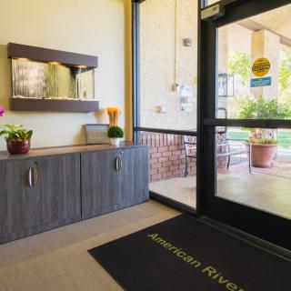 A welcoming entrance area with a door mat, plants, and decorative elements.