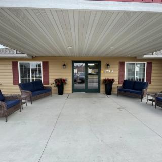 The entrance of a building with outdoor seating and decorative plants.
