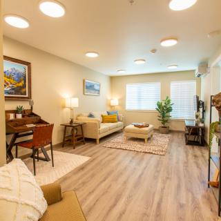 A cozy living room featuring a sofa, piano, and elegant decor with warm lighting.