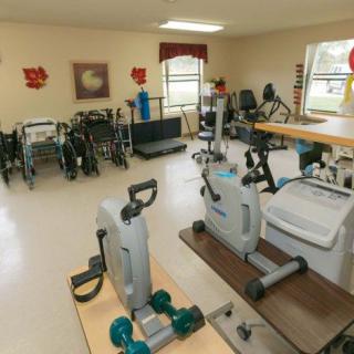 A well-equipped physical therapy room featuring various exercise machines and rehabilitation tools.