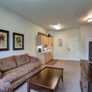 A cozy living room with a sofa, coffee table, and kitchenette.