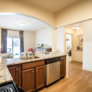 A modern kitchen with wooden cabinets and stainless steel appliances.