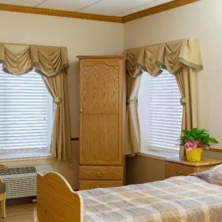 A cozy bedroom featuring wooden furniture and elegant curtains.