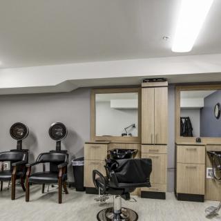 Modern hair salon interior with styling stations and hair dryers.