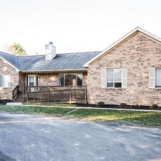 A single-story brick house with a driveway and front porch.