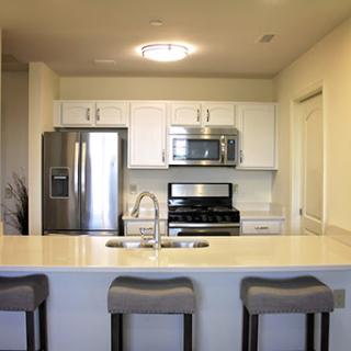 A modern kitchen featuring sleek appliances and a spacious island with bar stools.