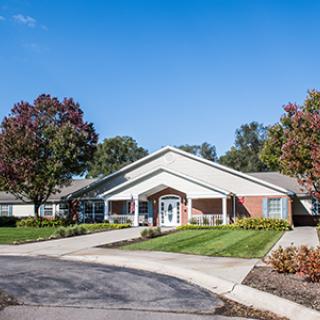 A suburban residential building with a landscaped front yard and driveway.