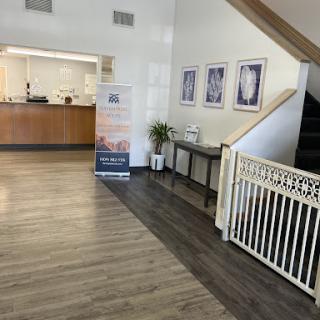 A welcoming lobby area featuring a reception desk and stairs, complemented by modern furnishings and decor.