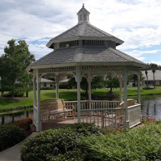 A charming gazebo surrounded by greenery and water, perfect for relaxation.