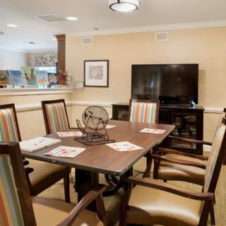 A cozy dining area with a table and chairs, featuring a television and decorative elements.