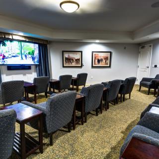 A conference room with multiple chairs facing a TV screen and artwork on the walls.
