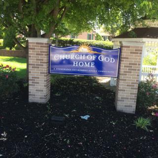 A welcoming sign for the Church of God Home, surrounded by well-maintained landscaping.