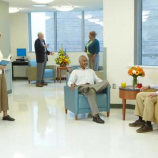 A modern waiting room with people sitting and conversing.