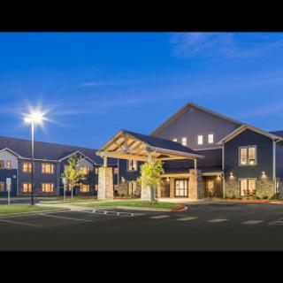 A beautifully lit modern building at dusk, showcasing its architectural features and inviting entrance.