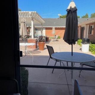 A sunny outdoor patio area with tables and umbrellas.